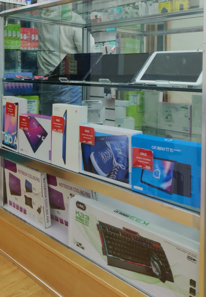 Display case of watches and fragrances at Sid Mobiles in Stoke Newington.