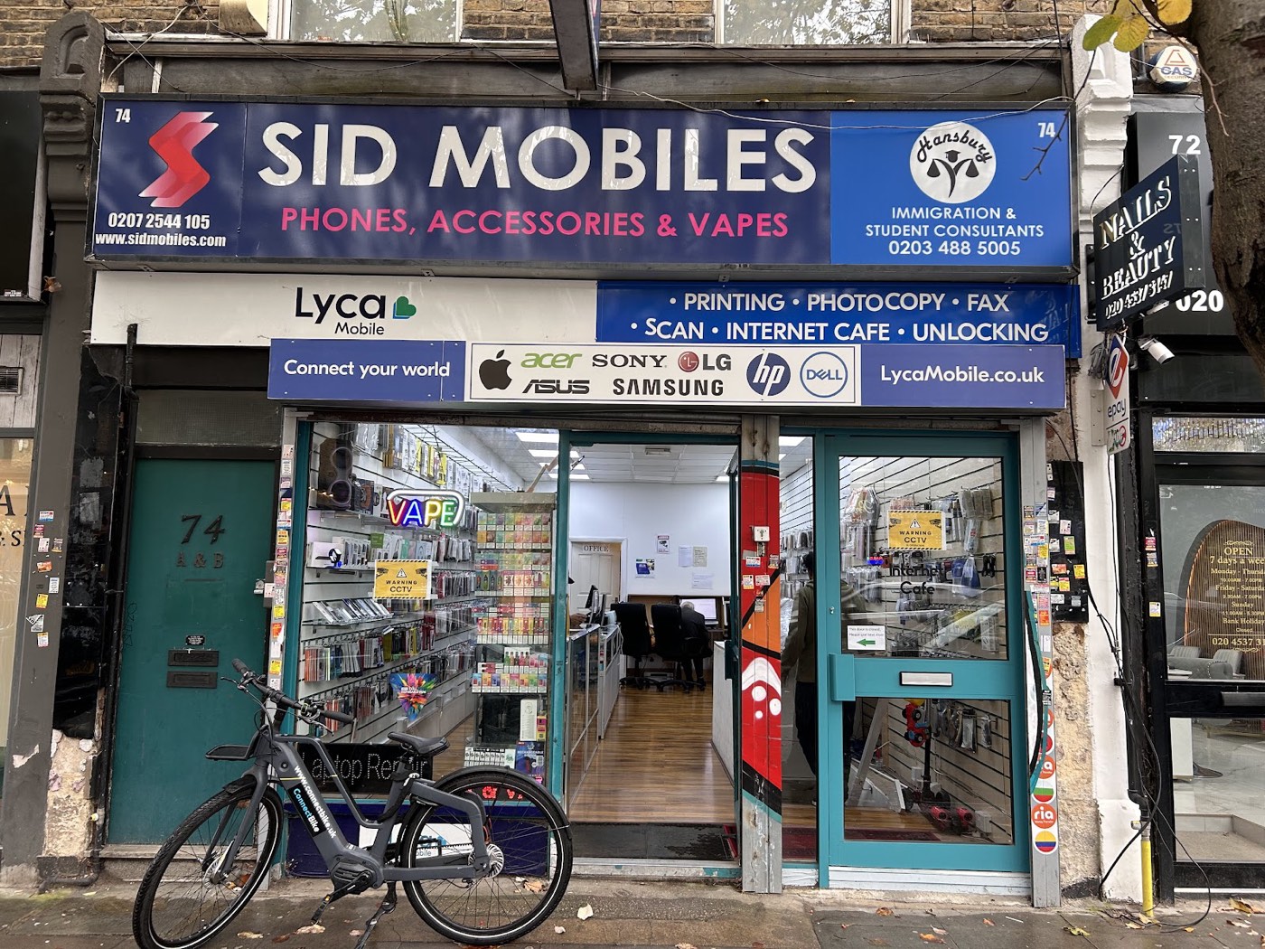 The Sid Mobiles & Vapes shopfront at 74 Stoke Newington High Street, blue signage reading Sid Mobiles, phones, accessories and vapes.
